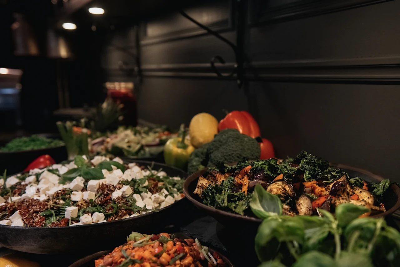 A delicious buffet spread at Home Hotel Kung Oscar featuring fresh salads, roasted vegetables, and vibrant greens.