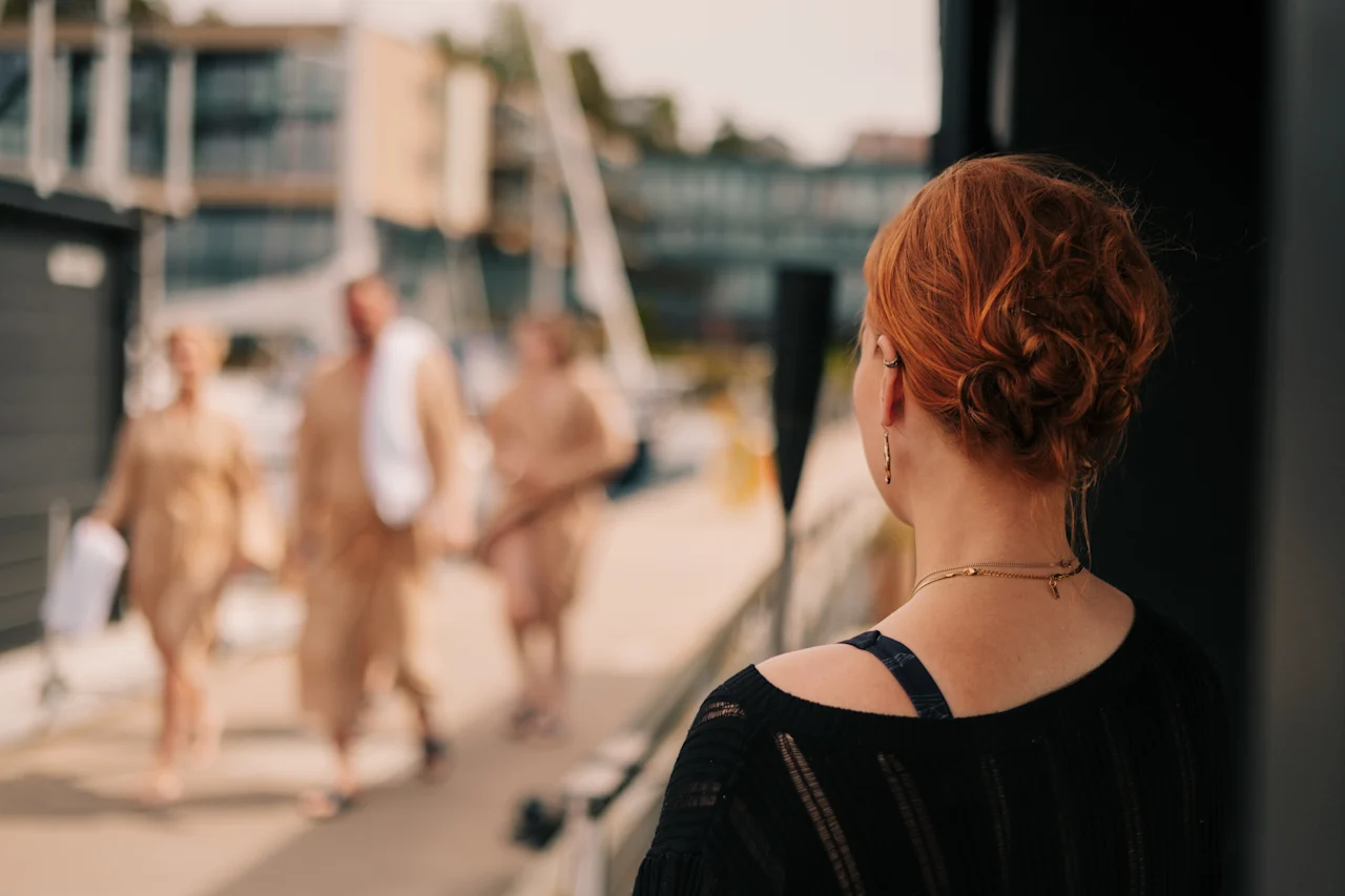 Bagfra ser en person andre spadsere forbi i behageligt tøj, mens de nyder en udendørs fritidsaktivitet.