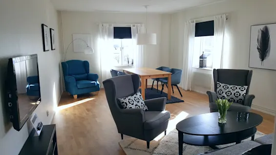 Bright and modern living area featuring a dining table and cozy armchairs.