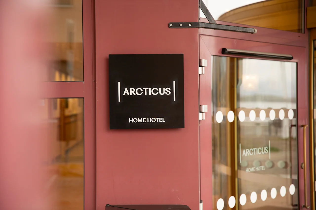 A hotel entrance featuring a sign with the words ARCTICUS HOME HOTEL.