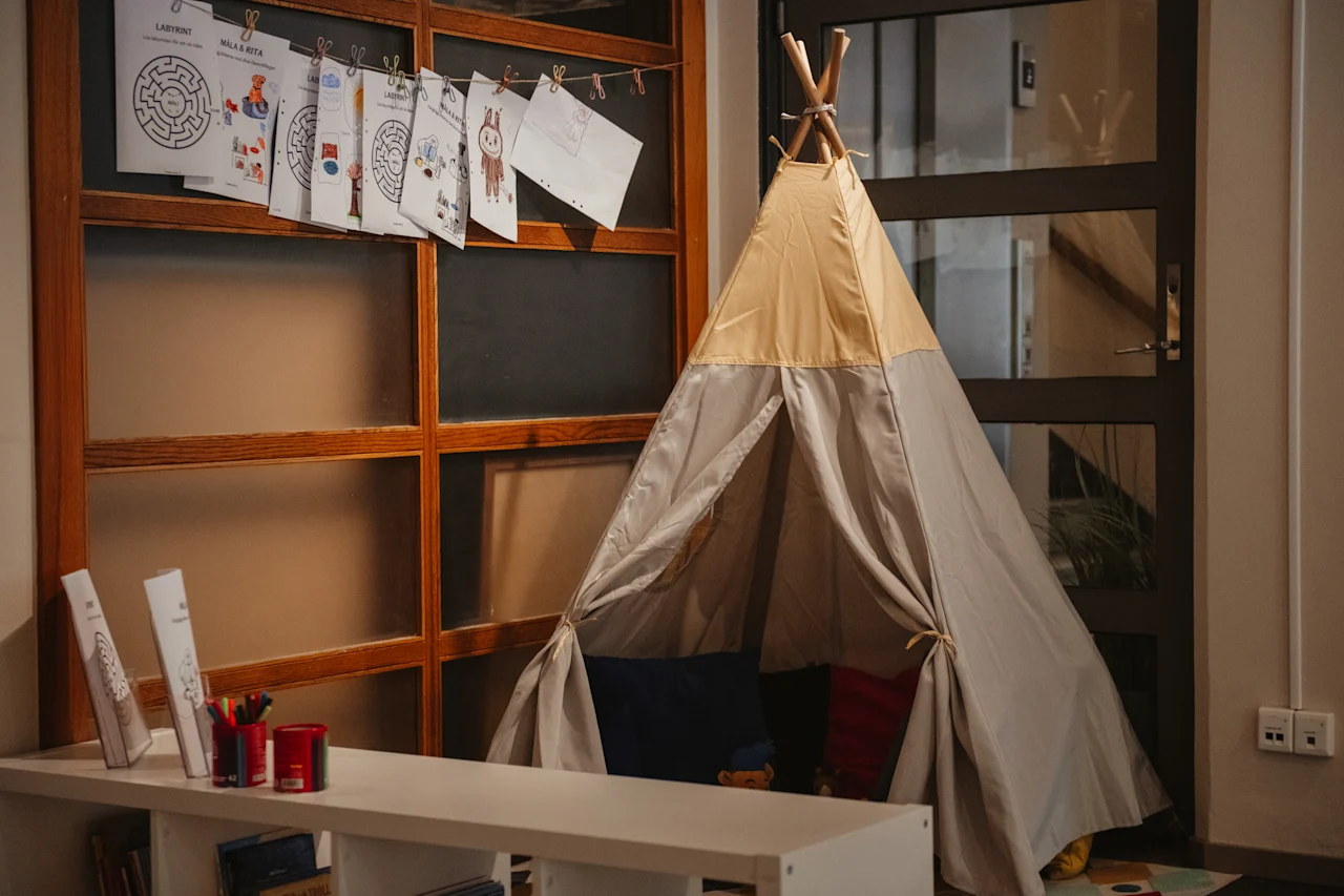A children's play corner featuring a teepee tent, with drawings and mazes like LABYRINT and MILLA & RITA displayed.