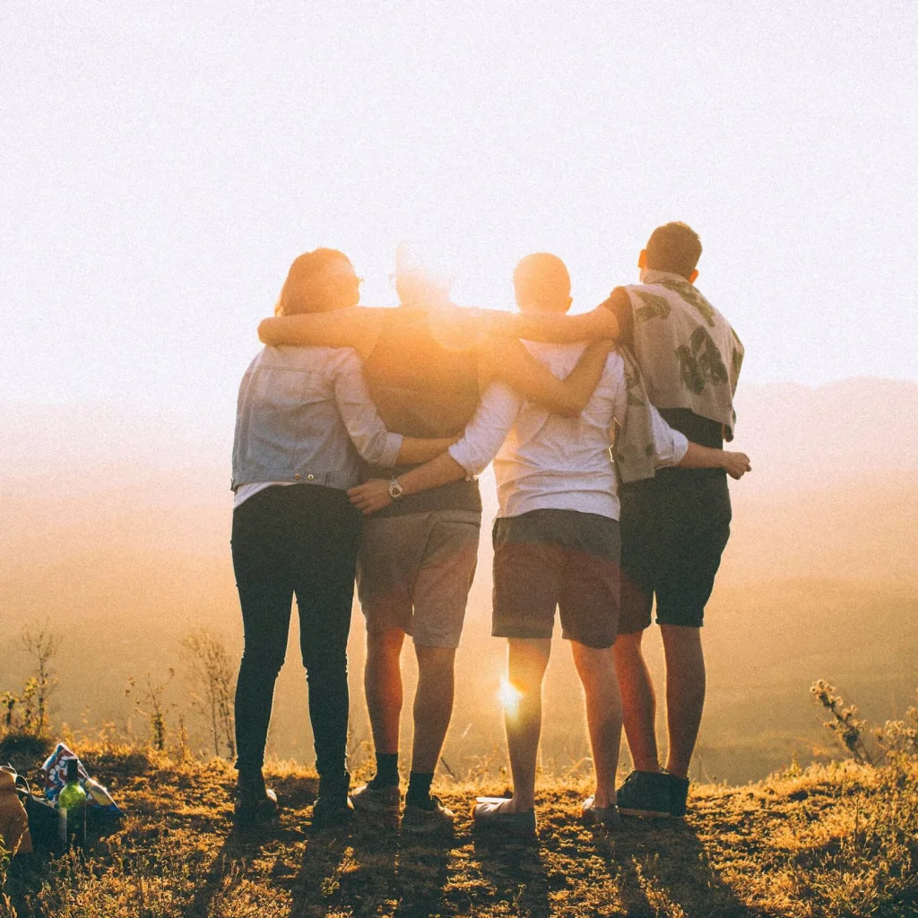 People hugging each other in the sunset.