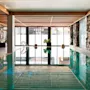 Indbydende indendørs poolområde på Quality Hotel Grand, Kongsberg, med naturligt lys, stenmure, hyggelig siddeplads og Grand Spa-reflektioner.