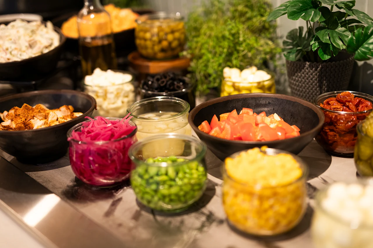 A diverse selection of fresh ingredients and toppings arranged buffet-style, ready for guests to customize their meal.