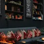 En hyggelig lounge med sofa, pejs og bogreoler. En menutavle viser Rott Vin, Rose, Cider, Cheers. Også Gastbok, Spillekort.