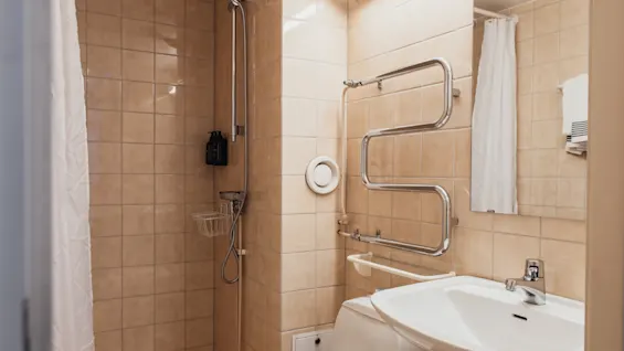 A bright and inviting bathroom at Home Hotel Kung Oscar, equipped with a shower, toilet, and sink for a refreshing experience.