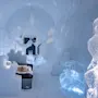 Et rum med isskulpturer har detaljeret møbler og dekorationer af is, inklusive en seng med et pelsplaid. Miljøet er oplyst med blåt lys, hvilket skaber en rolig atmosfære.
