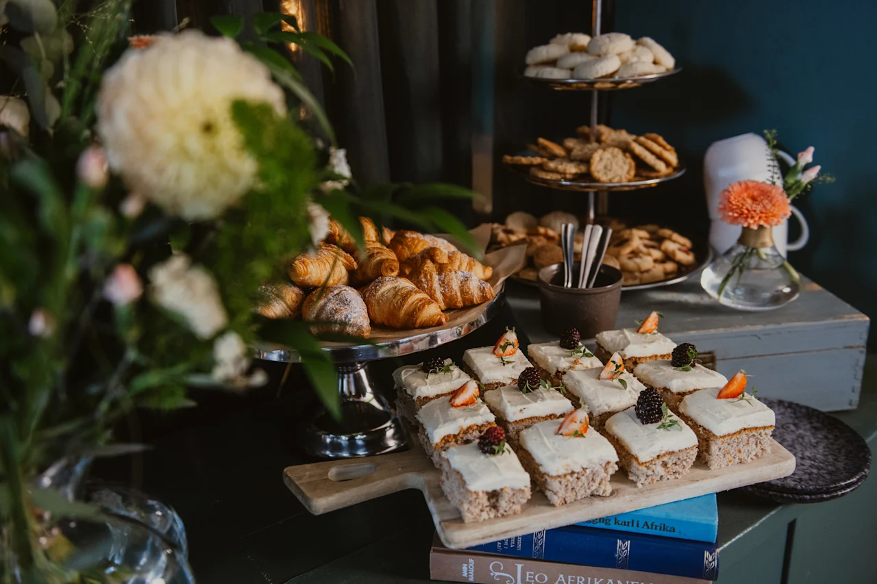 A delightful spread of pastries, including croissants, frosted cakes, and cookies, arranged on a table at Home Hotel Uppsala.
