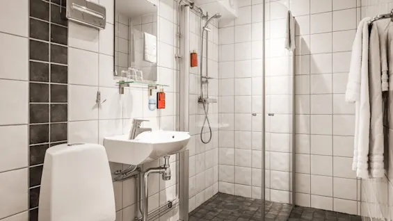 Siisti ja kutsuva kylpyhuone Comfort Hotel Linkoping Cityssa, jossa on suihku, wc ja pesuallas vieraiden mukavuutta varten.
