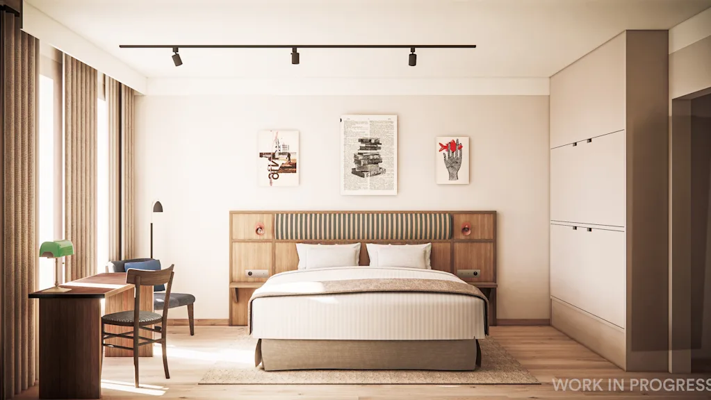 A modern hotel room with a bed, a desk, and artwork on the wall. Natural light fills the space. 