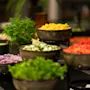 A vibrant buffet at Home Hotel Grand Bodø featuring bowls of fresh chopped vegetables, fruits, and leafy greens, ready for guests to enjoy.