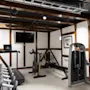 An inviting gym space with a variety of exercise equipment including cardio machines and free weights, ready for a workout.