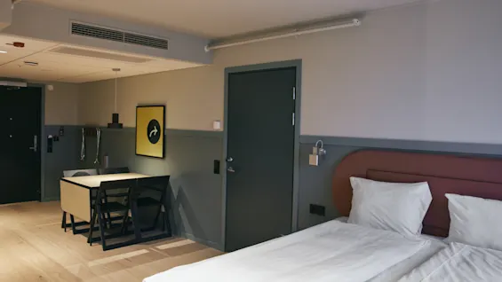 Ett välutrustat hotellrum på Stopover Hotel Falkenberg, med en bekväm säng och en mångsidig yta för middag eller arbete.