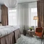 Lyst og koselig hotellrom med oppredd dobbeltseng, sittegruppe ved vinduet og et lite skrivebord.