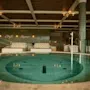 Et rolig syn av The Dock Spa med et stort sirkulært basseng, innbydende salongområder og mottoet 'Chill Drift Repeat'.
