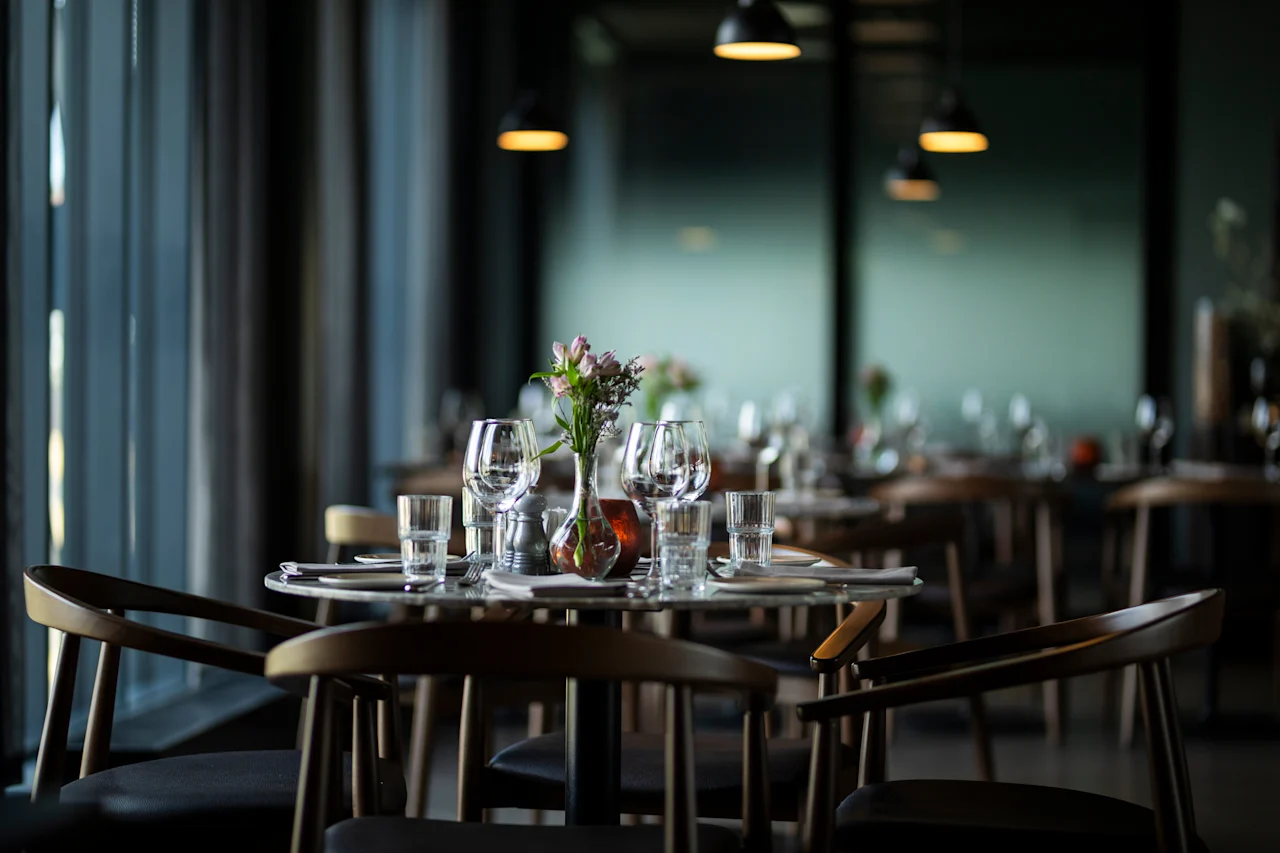 Et vakkert dekket bord i en dempet belyst restaurant, klart for gjester.