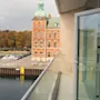 Kaunis näkymä parvekkeelta Quality Hotel Öresundissa, historiallinen rakennus vihreällä kupolilla, ranta ja katu.