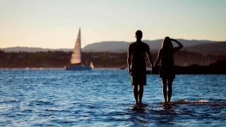Couple holding hands on a beach_16_9