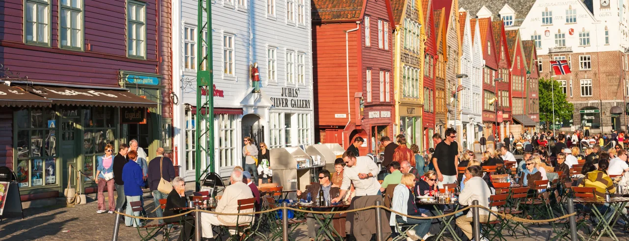 Bryggen in Bergen on a summer day, people enjoying the bayside restaurants.