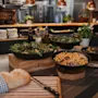 A vibrant buffet spread at Home Hotel Uppsala featuring fresh salads, olives, and a rustic loaf of bread, ready for serving.