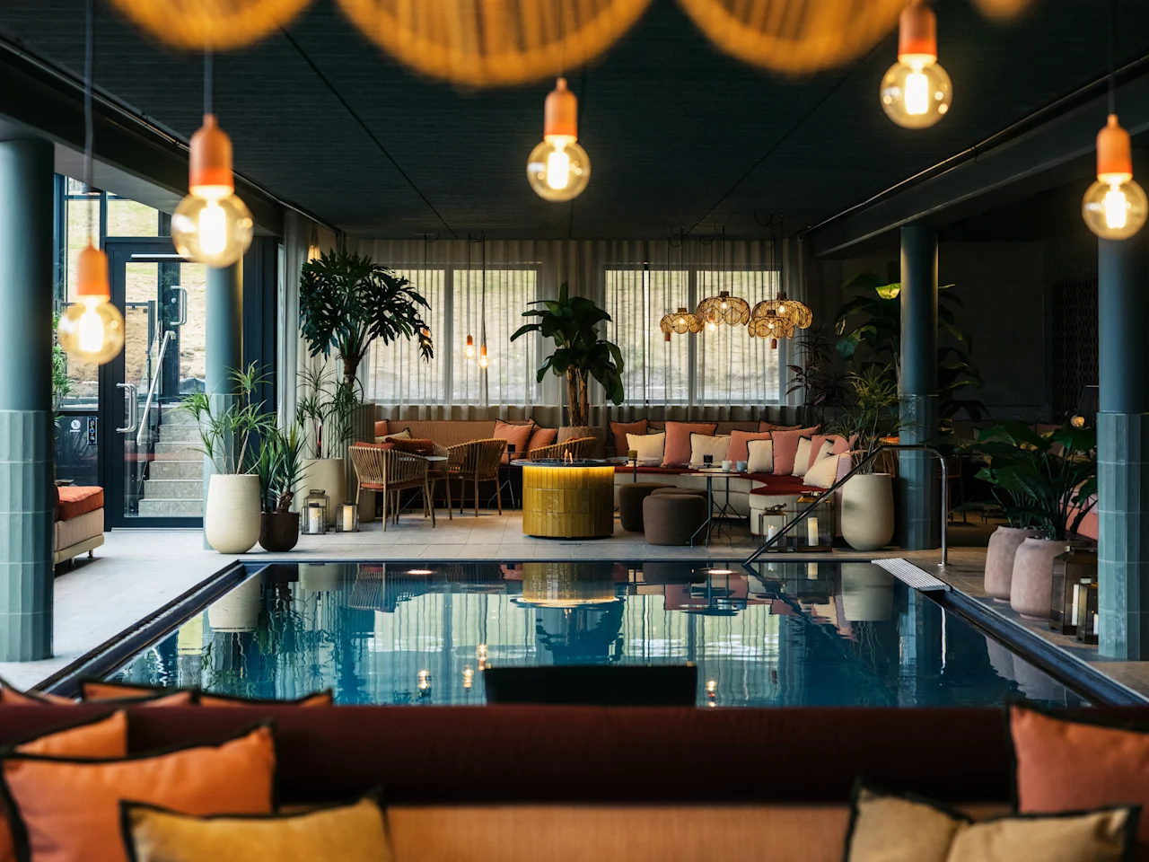 Indoor pool area at Lily Country Club with comfortable seating, lush plants, and warm, inviting lighting.