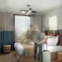 A person placing items on a bed in a modern hotel room with minimalistic decor, featuring a large window, teal and beige accents, wall-mounted TV, and overhead lighting.