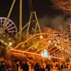 Lisebergs nöjespark i Göteborg på kvällen, med träd som glöder i orange och gyllene ljus under Halloween.