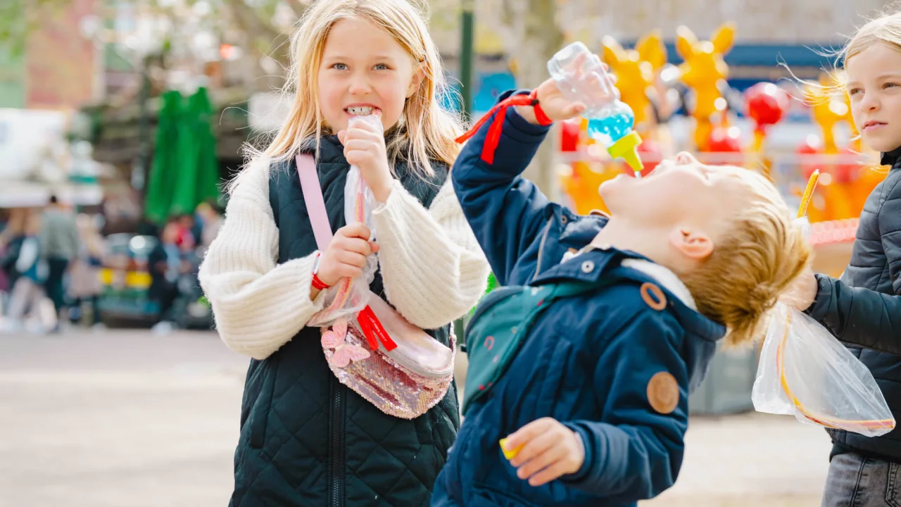 Kids eating candy at amusement park Bakken in Copenhagen.