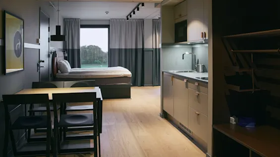 Ett modernt och funktionellt hotellrum på Stopover Hotel Falkenberg, med säng, matplats och pentry, med fönsterutsikt.