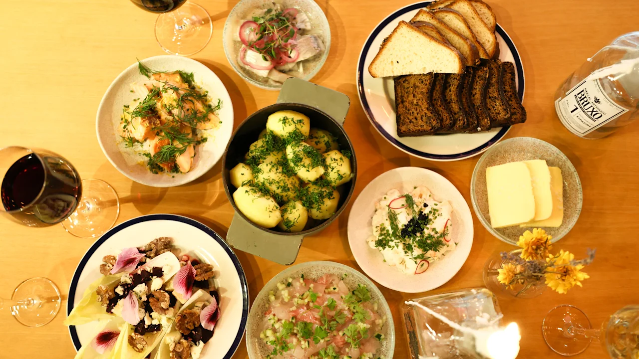 A festive table spread with a variety of dishes like potatoes, salads, and bread, with wine glasses ready for a meal.