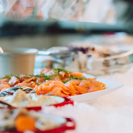 Raikas hotelliaamiaisbuffet jossa tarjolla lohta ja lisukkeita jäillä