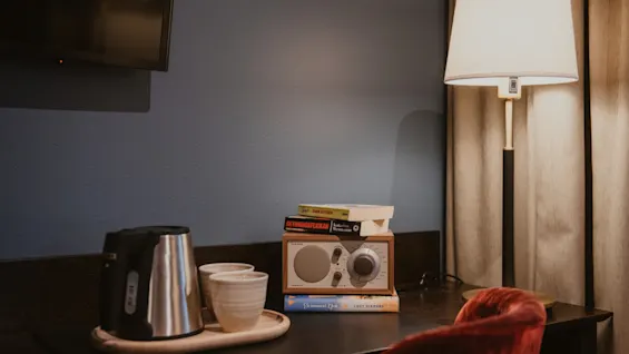 Home Hotel Kung Oscar: A cozy desk with a kettle, radio, and books: SKYMNINGSFLICKAN, KARA ALATYR, LUCY DIAMOND.