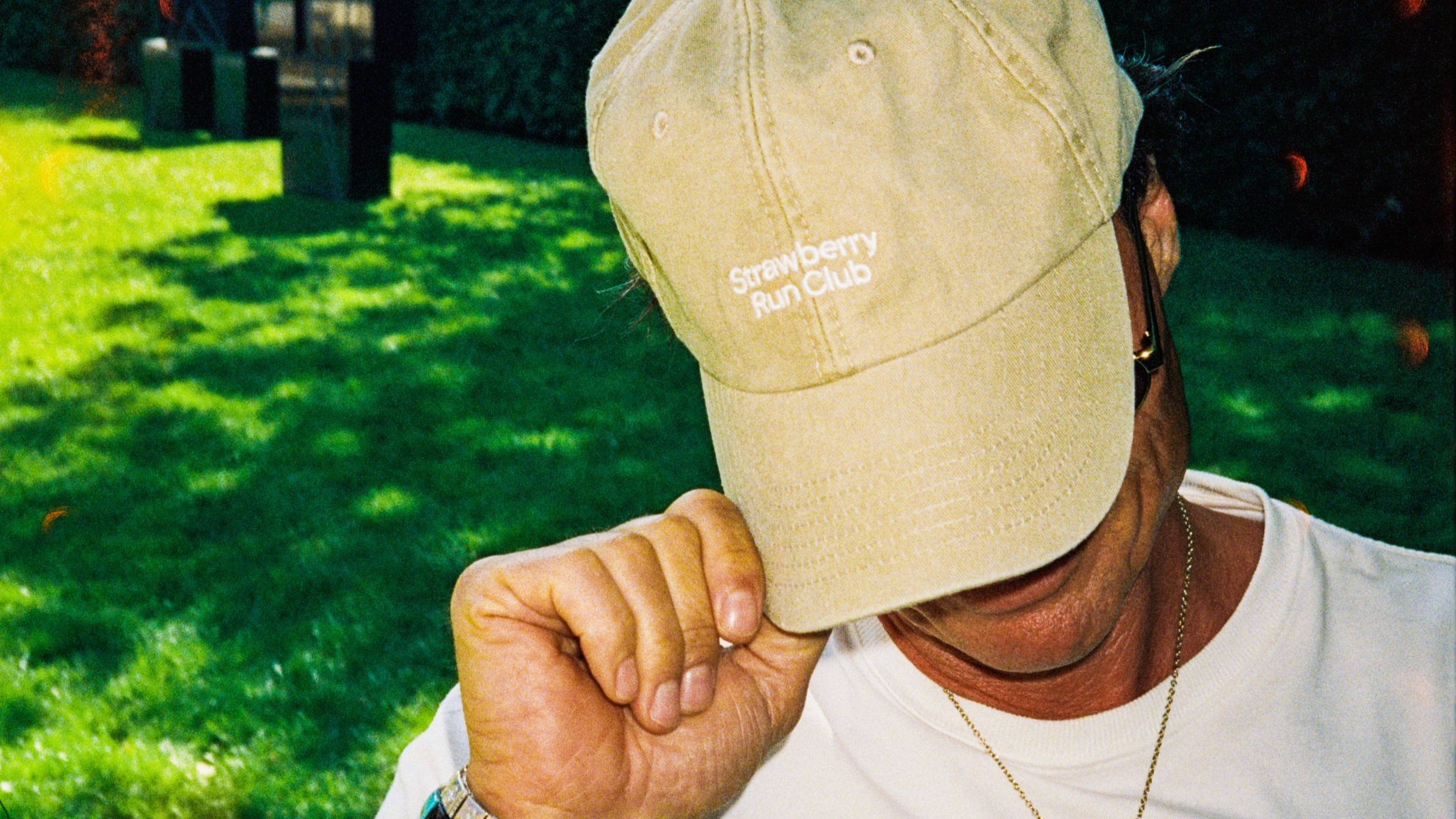 Petter Stordalen standing in a garden with a Strawberry Run Club cap on his head