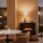 Cozy lounge area at Home Hotel Baltzar with a warm fireplace, comfortable seating, and elegant decor.