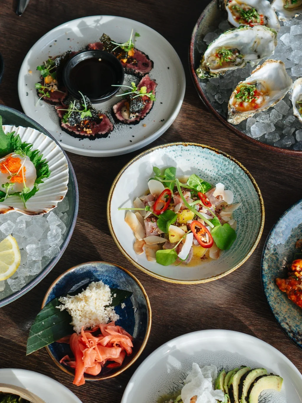 Ett färgstarkt utbud av fisk- och skaldjursrätter, inklusive sushi och ostron på is, på Clarion Hotel® Sea U:s Restaurant AMA. Bordet pryds med färgglada garneringar och färska ingredienser.