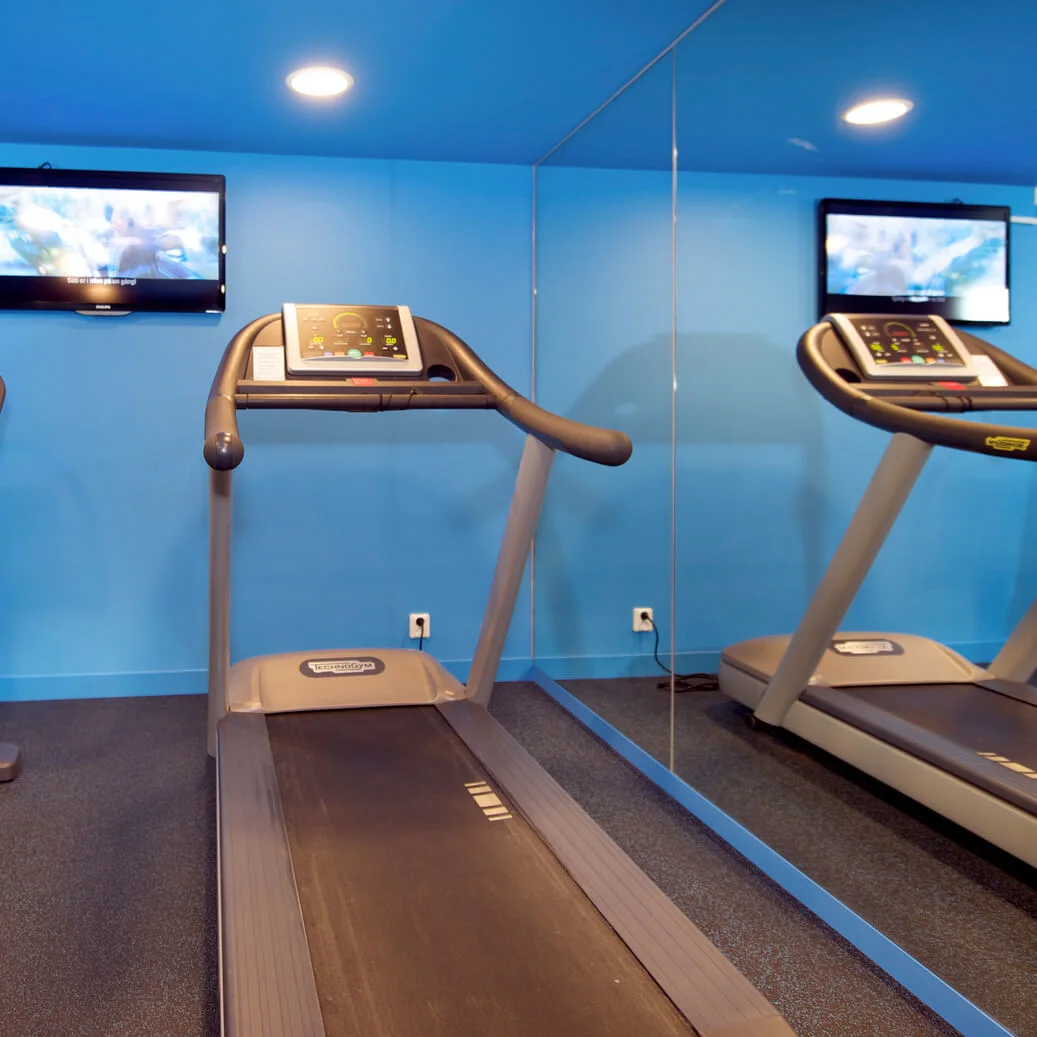 Exercise equipment in a blue-walled gym.
