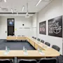 Meeting room with U-shaped wooden tables set with notepads and water bottles. Two chalkboards display "Dream BIG" and "THINK OUTSIDE THE BOX." Projector and screen installed overhead. 