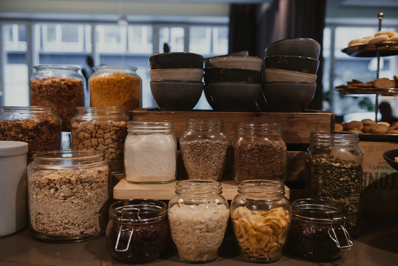 A delightful breakfast buffet at Home Hotel Uppsala, featuring an array of cereals, grains, and dried fruits in glass jars.