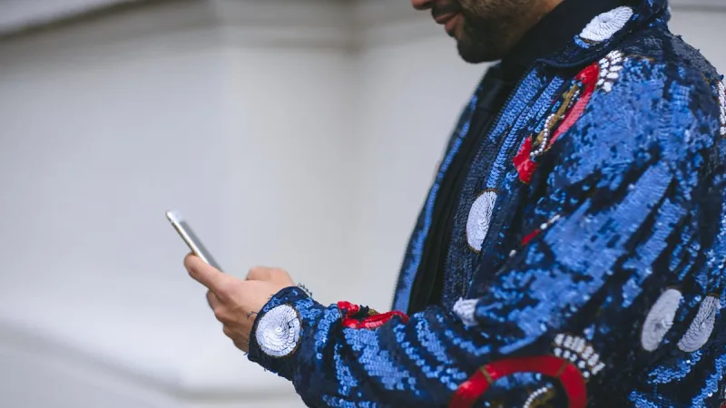 Man in glitter jacket with phone for Nordic Choice Club