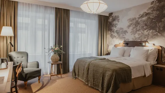 Home Hotel Baltzar - Superior Room. A cozy hotel room with a large bed, elegant wallpaper, and a comfortable seating area.