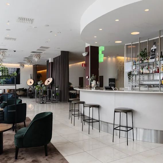 En inbjudande hotellounge med en elegant bar med olika drycker och mysiga sittplatser. 