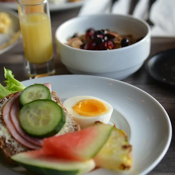 En härlig frukost med smörgås, kokt ägg, färsk frukt, juice och yoghurt.