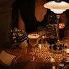 A cozy evening at Hotel Kämp – Kämp Bar, with various drinks on a patterned table under warm lighting.