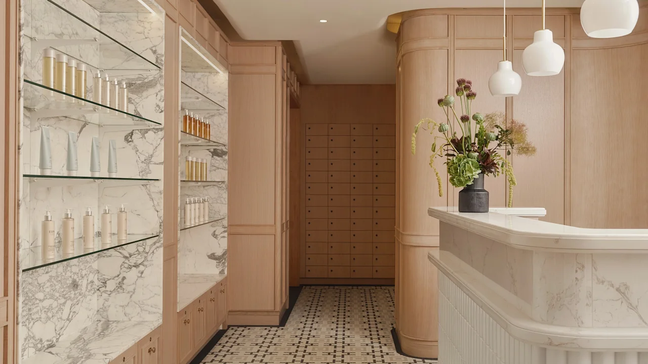 Elegant spa reception desk with marble counters and shelves displaying beauty products.