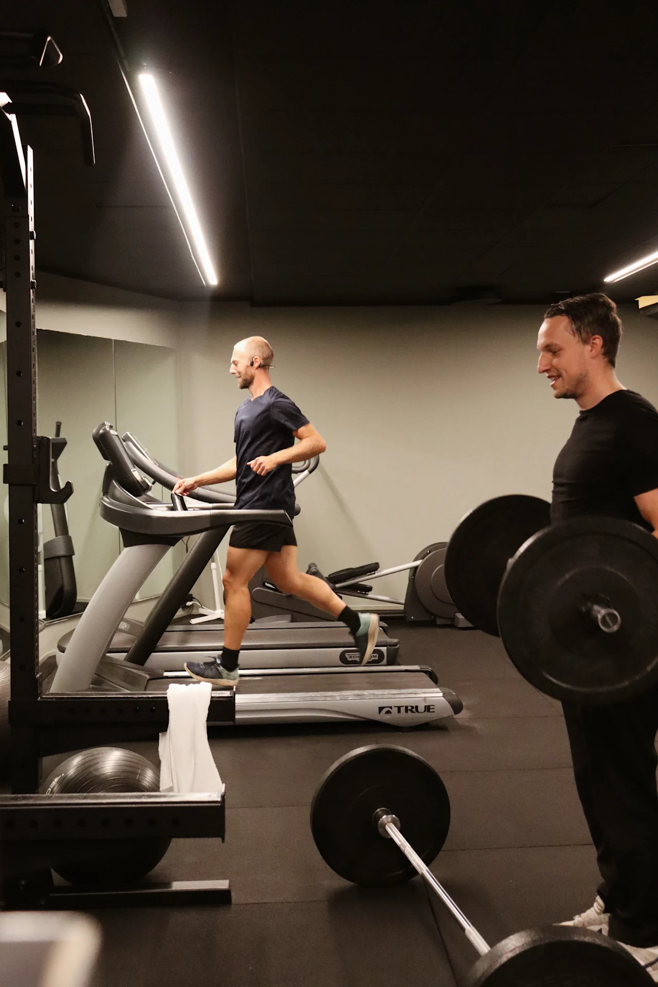 Gjester trener på treningsstudioet på Quality Hotel Park Södertälje, en løper på tredemølle og en annen løfter vekter.
