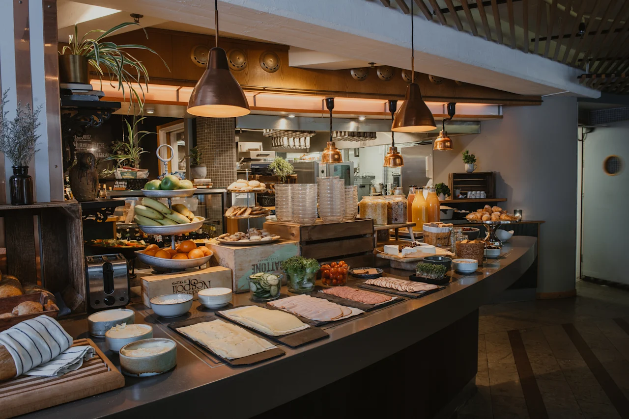 A delicious breakfast buffet at Home Hotel Uppsala, featuring fresh fruits, pastries, cold cuts, and juices, ready for guests.