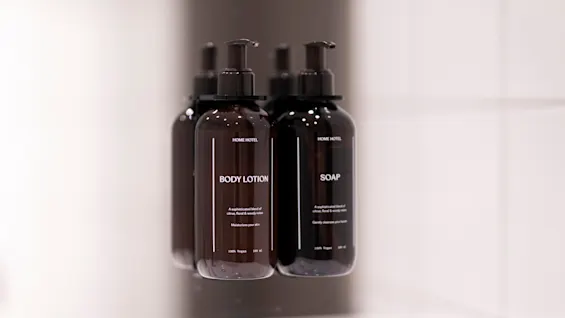 BODY LOTION og SOAP pumpeflasker reflekteres i et rent, lyst miljø.