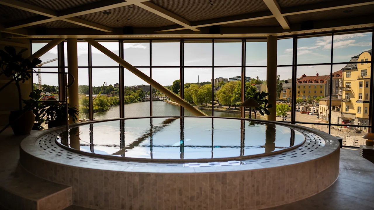 The Dock Spa: Rauhallinen sisäuima-allasalue, josta on suuri ikkuna ja luonnonkaunis näkymä joelle ja kaupungin rakennuksiin.