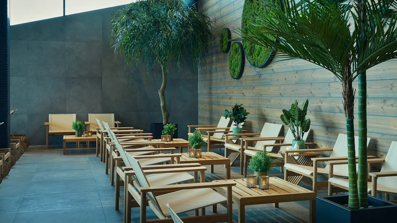 Tables and chairs with potted plants are arranged in a modern indoor seating area. Wooden walls and a tall tree enhance the natural ambiance.