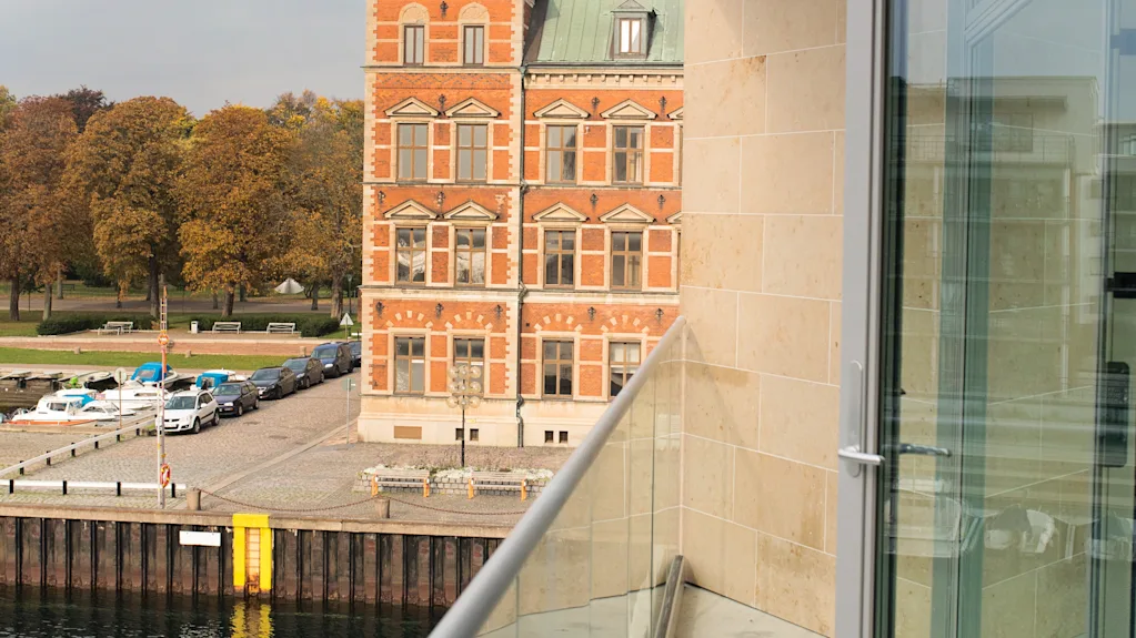 Kaunis näkymä parvekkeelta Quality Hotel Öresundissa, historiallinen rakennus vihreällä kupolilla, ranta ja katu.